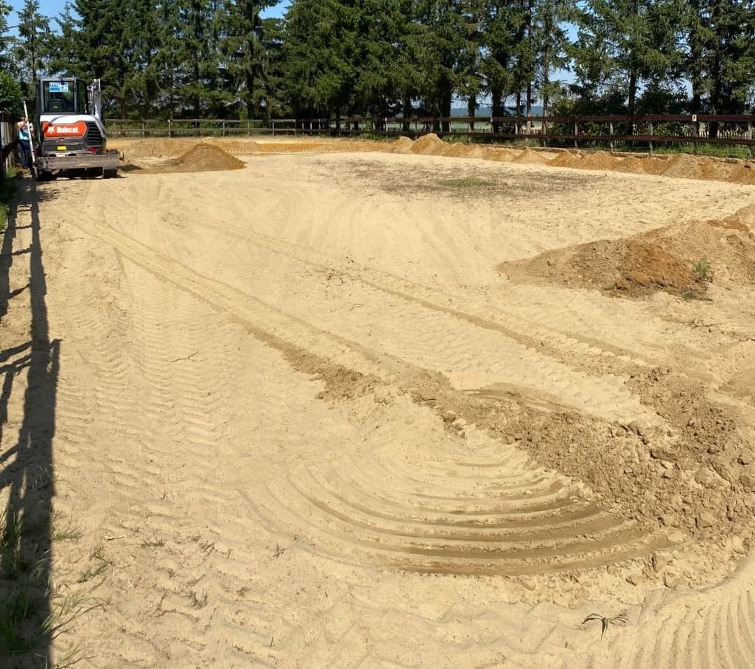 Une piste équestre, du sable remué au sol de travail, avant les travaux